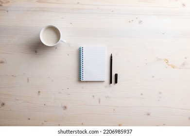 Blank Spiral Notebook And Open Black Spiral Pen Placed On Simple Wooden Desk With A Cup Of Fresh Coffee.