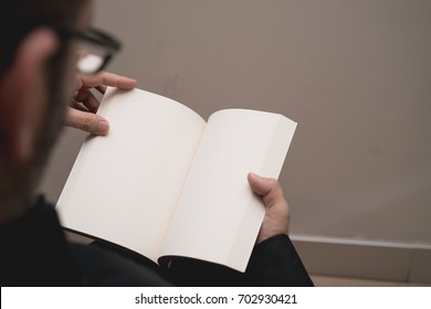 Blank spread, open book in man's hands - Shutterstock ID 702930421
