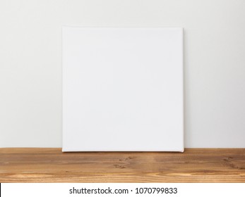 Blank Square Canvas Leaning Against A Gray Wall.