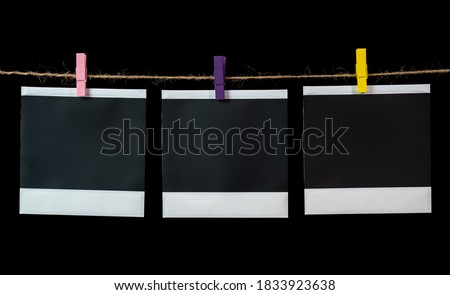 Blank square photo frames hanging on a clothesline.