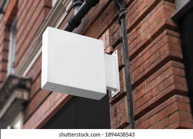 Blank Square Sign Mockup In The Urban Environment, On The Facade, Empty Space To Display Your Store Sign Or Logo