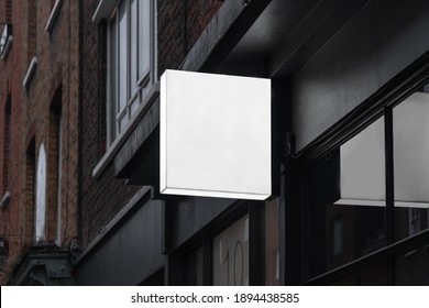 Blank Square Sign Mockup In The Urban Environment, On The Facade, Empty Space To Display Your Store Sign Or Logo