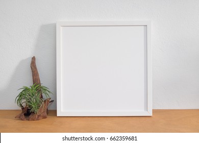 Blank Square White Frame With Plant On Wooden Shelf