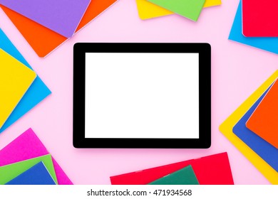 Blank Tablet With Colorfull Notebooks Around On Bright Pink Backgroud. Back To School.