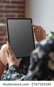 Blank tablet interaction in cozy setting, suitable as mockup