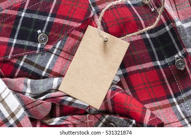 Blank Tag Made Of Recycled Paper On Clothes Background