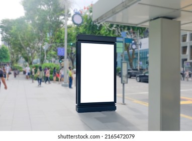 Blank Vertical Advertising Poster Banner Mockup At Bus Stop Shelter By Main Road, At City Centre; Out-of-home OOH Billboard Media Display Space. Out-of-focus People At Orchard Road