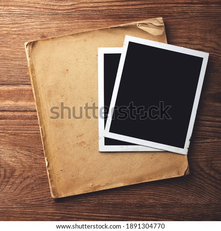 blank vintage paper and photo frame with space for your data on old wooden background