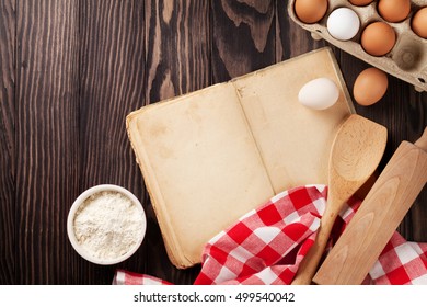 Blank vintage recipe cooking book, utensils and ingredients on wooden table. Top view with copy space - Shutterstock ID 499540042