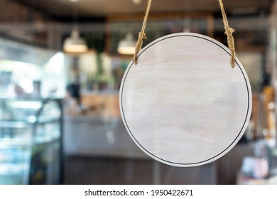 Blank Vintage Wooden Sign Board Hanging On Glass Door In Modern Cafe Restaurant, Copy Space For Text Advertising, Advertisement Marketing And Small Business Owner Concept