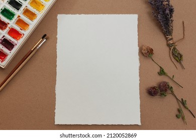 Blank Watercolor Paper Mockup With Watercolors And Brushes On Table Against Craft Paper Background 