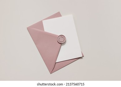 Blank Wedding Greeting Card, Invitation Mockup Scene In Sunlight. Closeup Of Pink Envelope With Decorative Wax Seal On Table. Birthday Stationery Template. Flat Lay, Top View. Feminine Composition.