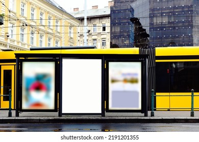 blank white ad panel. lightbox at tram stop. urban background. billboard for mockup sample image place holder. advertising background. glass aluminum structure. urban scene. yellow streetcar.