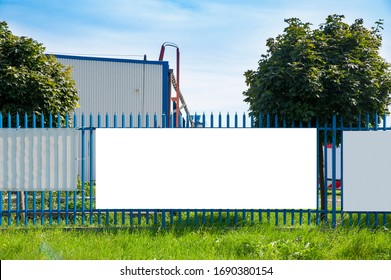 Blank white advertising banner on the fence of industrial building