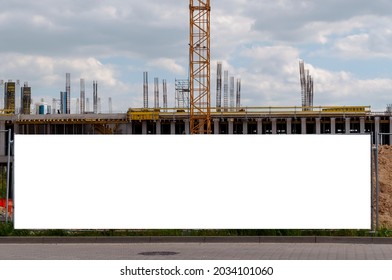 Blank white advertising banner on the construction cite fence - Shutterstock ID 2034101060