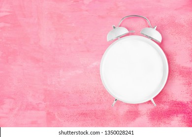 Blank White Alarm Clock With Twin Bells And Ringer With No Hands On Pink Background. Blank Clock Face, No Numbers, No Hands