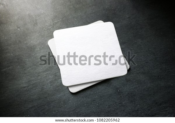 Blank white beer coaster stack mockup,\
top view, lying on the textured background. Squared clear can mat\
design mock up isolated. Quadrate cup rug\
display