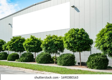 Blank white billboard for advertisement mounted on the wall of warehouse/factory