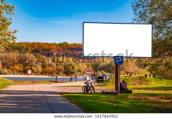 Blank white billboard for advertisement near\
the river ferry on a sunny autumn\
day