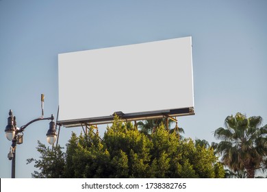 Blank White Billboard In Los Angeles, California Waiting For Promotional Material To Be Displayed Across Surface 