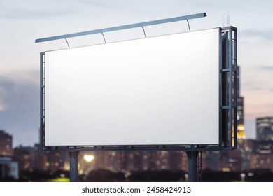 Blank white billboard on cityscape background at evening, perspective view. Mock up, advertising concept