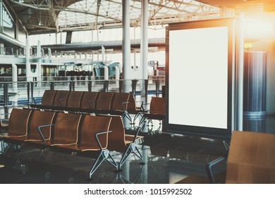 Blank White Billboard Placeholder Mockup In Shopping Mall; Empty Informational Banner In Airport Waiting Hall Or Waiting Room Of Railway Station Depot Surrounded By Rows Of Empty Wooden Seats