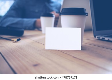 Blank White Business Card Mockup Wood Table Take Away Coffee Cup.Adult Businessman Work Modern Notebook Office Blurred Background.Clean Object Ready Private Corporate Information.Horizontal Mock Up