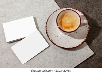 Blank white business cards on the table, with cup of coffee. Mockup for branding identity. Possibility to show both sides of card. Template for graphic designers. Free space, copy space.