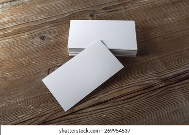 Blank White Business Cards On A Dark Wooden Background. Mockup For Branding Identity. Template For Graphic Designers Portfolios. Top View. Shallow Depth Of Field. 