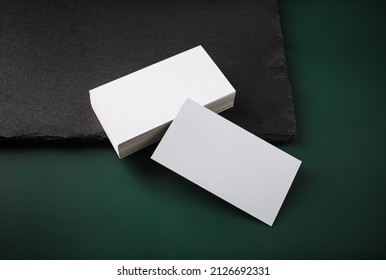 Blank White Business Cards And Stone Board On Green Table Background. Copy Space.