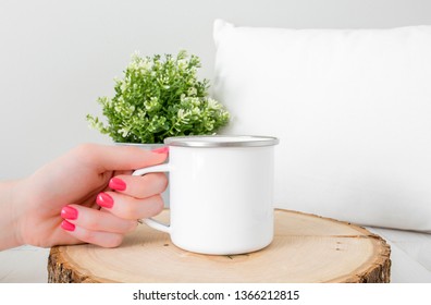 Blank White Camping Coffee Mug Held With Hand On Wood Slice With Pillow And Plant Background, Cup Mock Up