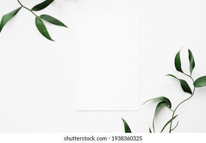 Blank White Card, Green Leaves On White Background As Botanical Frame Flatlay, Wedding Invitation And Holiday Branding, Flat Lay Design Concept