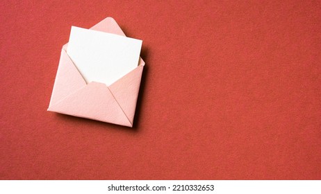 Blank white card with pink paper envelope template mock up on red background - Shutterstock ID 2210332653