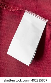 Blank White Clothes Label On Red Cloth As A Background