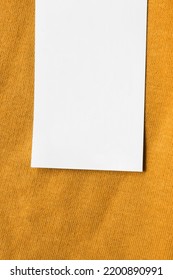 Blank White Clothing Label Closeup On Yellow Fabric