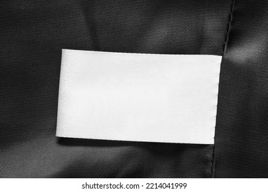 Blank White Clothing Label On Black Satin Fabric As A Background