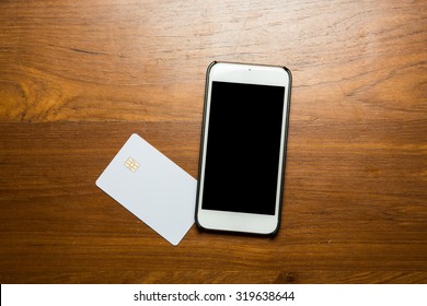 Blank White Credit Card With Smartphone On Table. View From Top.