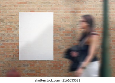 Blank White Crumpled Poster On Street Brick Wall. Young Woman Passing