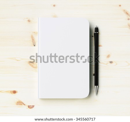 Blank white diary cover with pen on wooden table, mock up