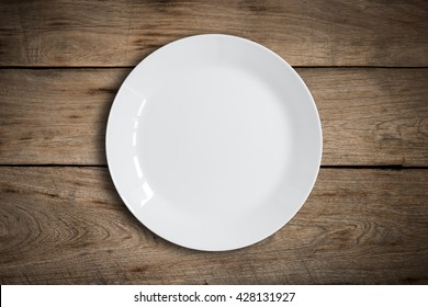 Blank white dish on a wood background.