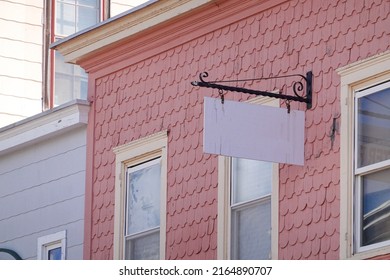 A blank white extending from a house with pink wooden shingles