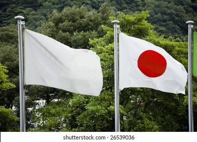 A Blank White Flag Flying Next To The Japanese Flag.