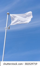 Blank White Flying Flag On A Blue Sky