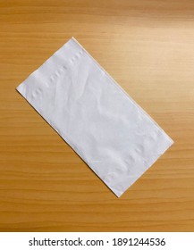 Blank white folded tissue paper on wooden table.Top view.