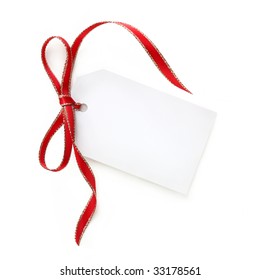 Blank White Gift Tag With Red And Gold Ribbon Bow.  Isolated On White With Soft Shadow.