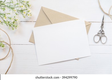 Blank White Greeting Card With Brown Envelop And Daisy Flowers On Wooden Table With Vintage Tone