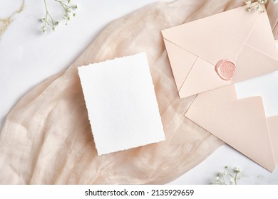 Blank White Invitation Card With Pink Envelopes And Gypsophila Branches. Wedding Stationery Set. Flat Lay, Top View, Copy Space.