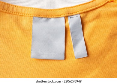 Blank White Laundry Care Clothes Label On Yellow Fabric Texture Background