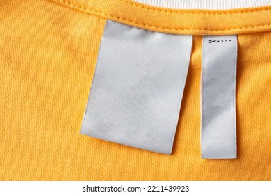 Blank White Laundry Care Clothes Label On Yellow Fabric Texture Background