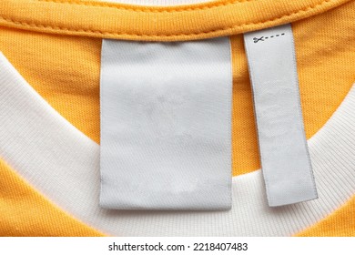 Blank White Laundry Care Clothes Label On Yellow Fabric Texture Background